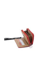 Billetera corta de diseño capitoneado con cierre perimetral y solapa frontal. Cuenta con compartimentos internos para tarjetas y billetes, e incluye una correa de mano desmontable.