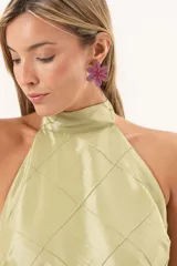 Vestido largo verde con cuello halter, cuerpo con diseño de rombos pespuntados y falda fluida transparente.