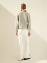 Campera bomber gris confeccionada en tejido combinado de neoprene, con escote bordado artesanalmente con piedras y cierre frontal con cremallera.