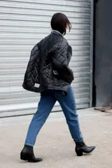 Pantalón jean gris metalizado, corte mom jean, con cuatro bolsillos, cierre y botón metálicos.