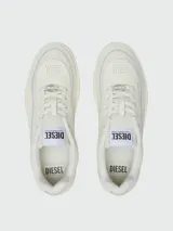 Zapatillas Diesel modelo S-Oval Skate, de diseño urbano en color crema. Presentan una silueta de perfil bajo con paneles de cuero y tejido técnico, cierre de cordones con placa metálica decorativa y etiqueta con logo en la lengüeta.