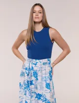 Vestido midi combinado de la marca Figueroa & Flower, con torso de modal azul sin mangas y cuello redondo, y falda evasé de rayón con estampado floral y paisajes en tonos blancos y azules, con cintura elastizada y lazo para anudar.