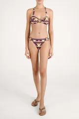 Calzón de bikini con diseño geométrico multicolor y argollas de madera en los laterales.