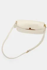 Bolso bandolera alargado de color blanco marfil con solapa redondeada y detalle metálico dorado. Incluye doble asa bandolera ajustable, una de ellas en tejido.
