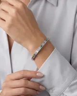 Esclava rígida de acero inoxidable con diseño de eslabones cuadrados planos, decorada con circonias engastadas en colores verde, violeta y rosa.