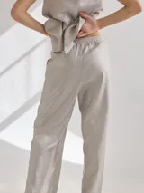 Pantalon de corte recto y tiro medio, confeccionado en lino, con cintura elastizada y tajos laterales en el ruedo.