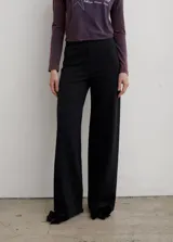 Pantalón de corte semi oxford confeccionado en punto roma, con cintura elástica y detalle de moños decorativos en el ruedo.