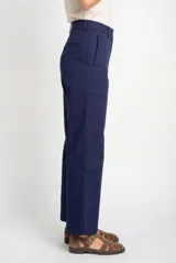 Pantalón de vestir azul marino, tiro alto, con cierre frontal de dos botones y corte ancho y recto.