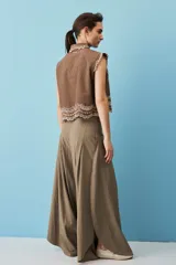 Pantalón marrón de corte ancho y fluido, con pinzas frontales y tiro alto.