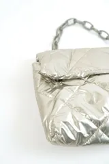 Cartera acolchada negra de material sintético con efecto brillante y costuras en rombos. Cuenta con solapa frontal y una correa corta de cadena gruesa de eslabones plásticos negros.