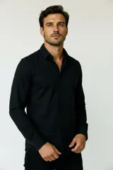 Camisa de poliéster color marrón, de corte holgado, con mangas largas, cuello camisero clásico y cierre frontal de botones.