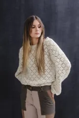 Buzo de lana mezcla tejido a mano con diseño de rombos calados, cuello bote, mangas estilo farol y terminaciones en punto elástico en cuello, puños y ruedo.