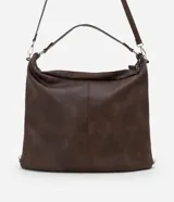 Bolso hobo grande de poliuretano color bordó, de diseño desestructurado con asas dobles y cierres laterales ajustables con tiradores. Cuenta con cierre superior y herrajes metálicos plateados.