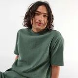 Remera de manga corta color verde en tejido texturizado tipo nido de abeja, con cuello redondo.