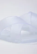 Sandalia chata de goma semi transparente color gris, con doble tira entrelazada sobre el empeine.