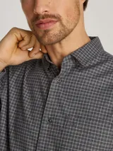 Camisa gris con estampado de cuadros pequeños, de corte regular, cuello en punta, manga larga, bolsillo de parche en el pecho, bajo redondeado y logo bordado en el pecho.