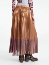 Falda midi metalizada color bronce con textura plisada y pretina elástica. Tiene un panel inferior color lila.