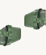 Sandalias de tacón alto color verde oliva, con punta cuadrada, tiras con tachas piramidales y pulsera al tobillo con hebilla.