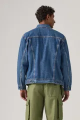 Campera de jean estilo trucker con corte relajado, cierre frontal con botones metálicos, bolsillos en el pecho con solapa y etiqueta roja distintiva de la marca.