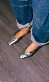 Mocasines de cuero metalizado en tono gris oscuro, con diseño de punta cuadrada y costura central en la capellada.