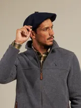 Boina azul marino de paño con visera pequeña y botón decorativo en la parte superior.