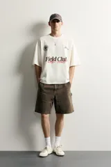 Bermuda relaxed fit color marrón con efecto lavado, cinco bolsillos, bolsillos frontales de carpintero y cierre frontal con cremallera y botón.