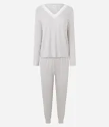 Pijama de dos piezas confeccionado en tejido ribana, compuesto por una remera de manga larga con escote en V y detalle de encaje, y un pantalón largo con cintura elástica.