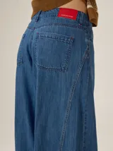 Pantalon de corte ancho y holgado, confeccionado en mezcla de algodón y lyocell. Presenta un diseño fluido con costuras verticales decorativas y bordado sutil en la pierna.