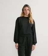 Buzo negro de algodón, de corte holgado, cuello redondo y mangas largas.