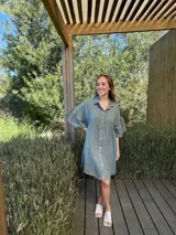 Vestido camisero blanco de lino italiano, con cuello camisero, cierre frontal con botones, mangas cortas con doble volado y bolsillos laterales.