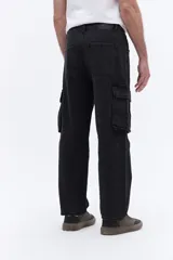 Pantalón tipo cargo confeccionado en denim de algodón con efecto lavado. Presenta un calce relajado de tiro medio, con bolsillos laterales tipo cargo y costuras reforzadas en las rodillas.