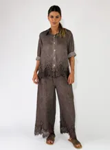Pantalon de lino color chocolate, de corte ancho, con detalle de encaje bordado en el ruedo.