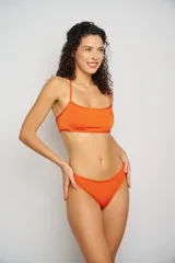 Conjunto de bikini marrón con ribetes blancos, compuesto por un corpiño triangular y una bombacha tipo tanga.