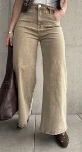 Pantalón de jean color beige con efecto óxido, de tiro alto y corte ancho en las piernas.