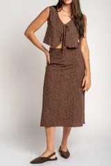 Falda midi de corte recto, color marrón con estampado de lunares pequeños en tono claro. Presenta un diseño de tiro alto y largo hasta la pantorrilla.
