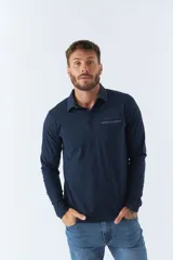 Polo de manga larga azul marino con cuello clásico, cierre de dos botones y bolsillo en el pecho con detalle de marca.