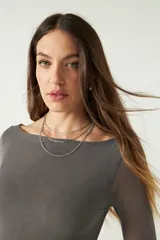 Top de manga larga confeccionado en tejido de tul con transparencias, de corte ajustado y cuello redondo.