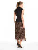 Vestido midi de estilo sastre con cuerpo tipo chaleco negro de cuello solapa y escote en V, con cierre lateral y cinturón con hebilla. La falda es plisada con estampado animal print y cuenta con forro interno.