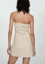 Vestido corto tipo palabra de honor, con diseño recto y drapeado. Presenta una textura con patrón de rayas en relieve y cierre de cremallera invisible en el lateral.