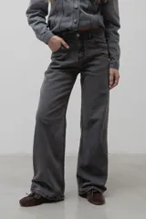 Jean de corte recto y tiro medio, confeccionado en denim de color gris oscuro con efecto lavado. Presenta cierre frontal con botón metálico y bolsillos laterales.