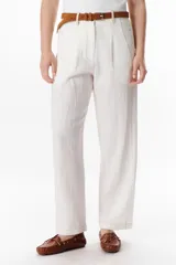 Pantalón de lino color marrón oscuro, tiro alto, corte recto y holgado, con pinzas delanteras y pespuntes a contratono en blanco.