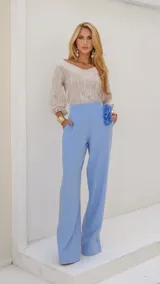 Pantalón celeste de vestir, de corte palazzo, con bolsillos laterales y detalle de flor en la cintura.
