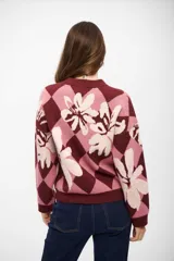 Buzo de tejido de punto con diseño de rombos y flores estampadas en tonos bordó, rosa y crema. Presenta cuello redondo, mangas largas y puños acanalados.