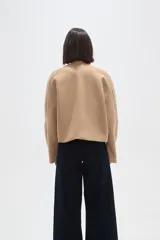 Tapado corto de paño color camel, con cuello redondo, cierre frontal de tres botones y mangas largas con diseño estructurado.