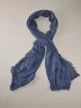 Chalina gris de tejido ligero y traslúcido, con textura arrugada y bordes desmechados con flecos cortos.