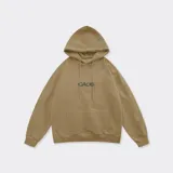 Buzo color beige con capucha, corte holgado, bolsillo tipo canguro y estampado frontal con la palabra "CAOS".