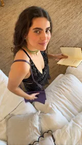 Vestido corto negro con estampado de plumas doradas, escote en V, breteles finos cruzados en la espalda, cut-outs laterales y volado en el ruedo.