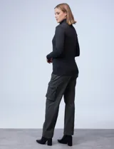 Polera gris de tejido fino con cuello alto y mangas largas con aplique de botones en los puños.