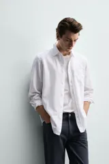 Camisa regular fit de manga larga con diseño a rayas verticales celestes y blancas. Cuenta con cuello abotonado, bolsillo de parche en el pecho y cierre frontal con botones.