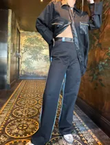 Pantalón negro de corte recto con detalle de franja celeste en el lateral.